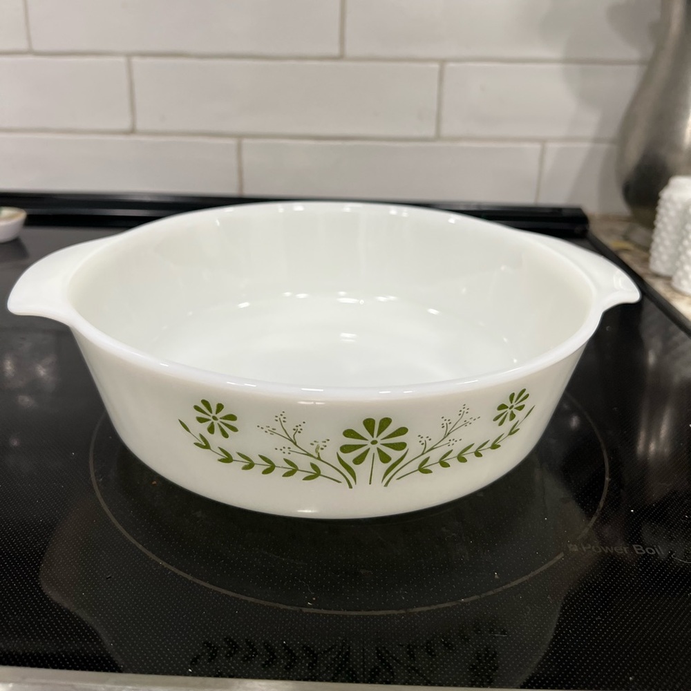 This is a vintage Glasbake casserole dish featuring the green daisy pattern.